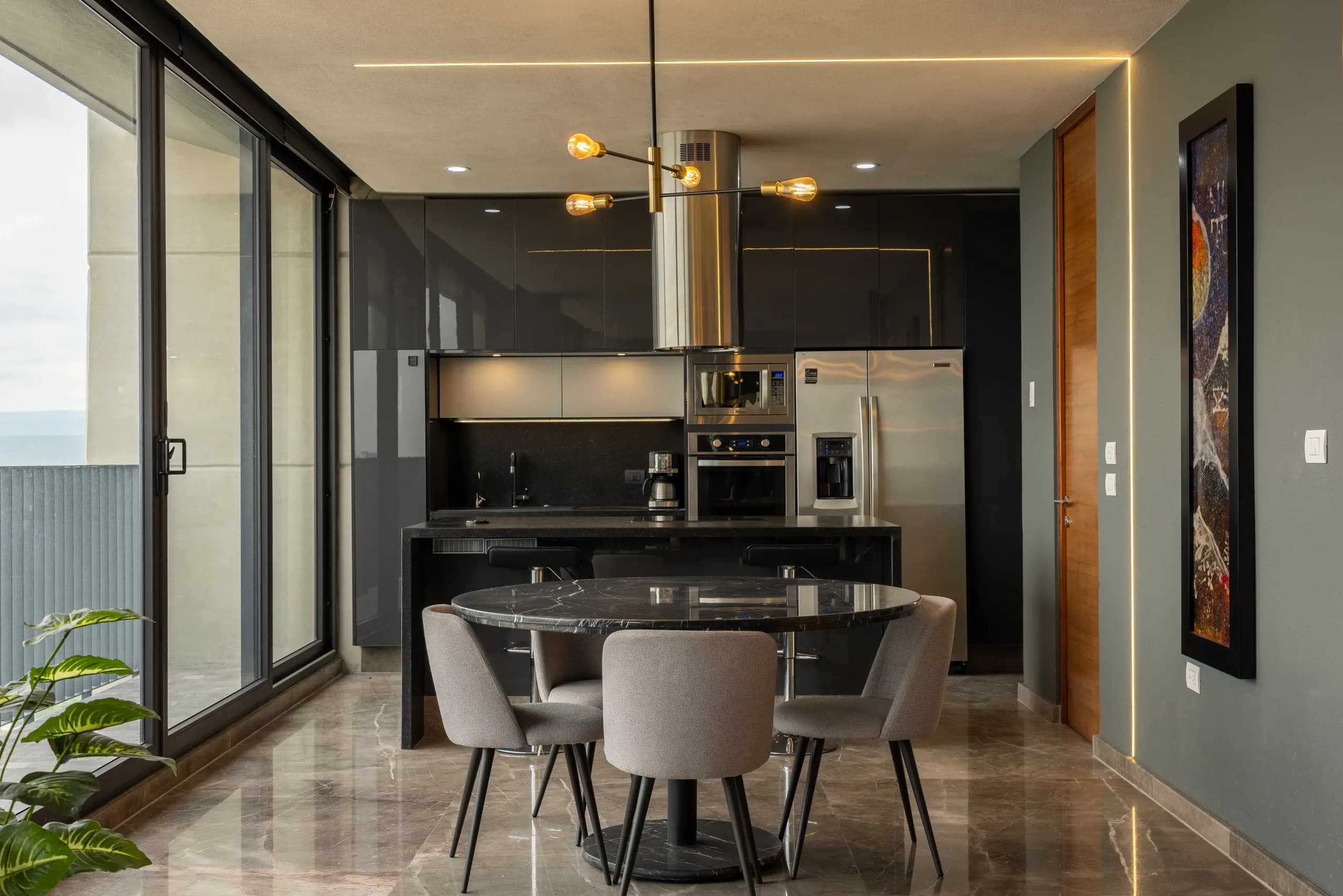Comedor y cocina integrados con lámpara colgante dorada